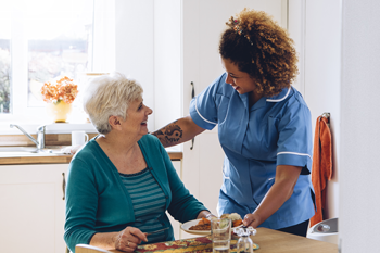 aide assisting senior woman